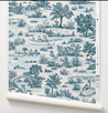 Roll of wallpaper with blue and white nature-themed design on a white background showing dogs playing.